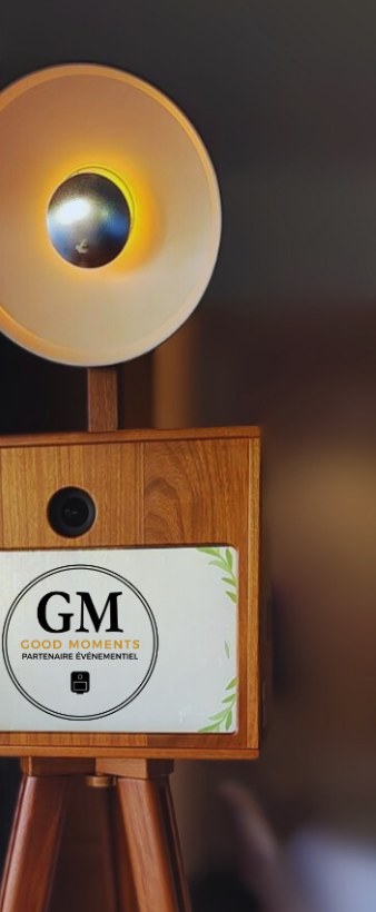 La borne en iroko sur son trépied, anneau lumineux allumé, cartel GM sur la façade